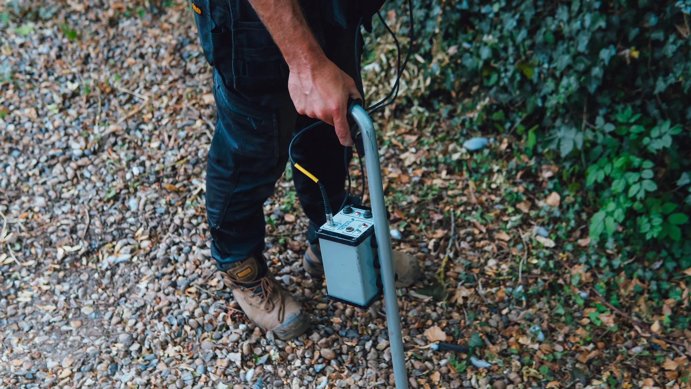 Close-up of an acoustic ground microphone and its amplifier box held on a gravel surface